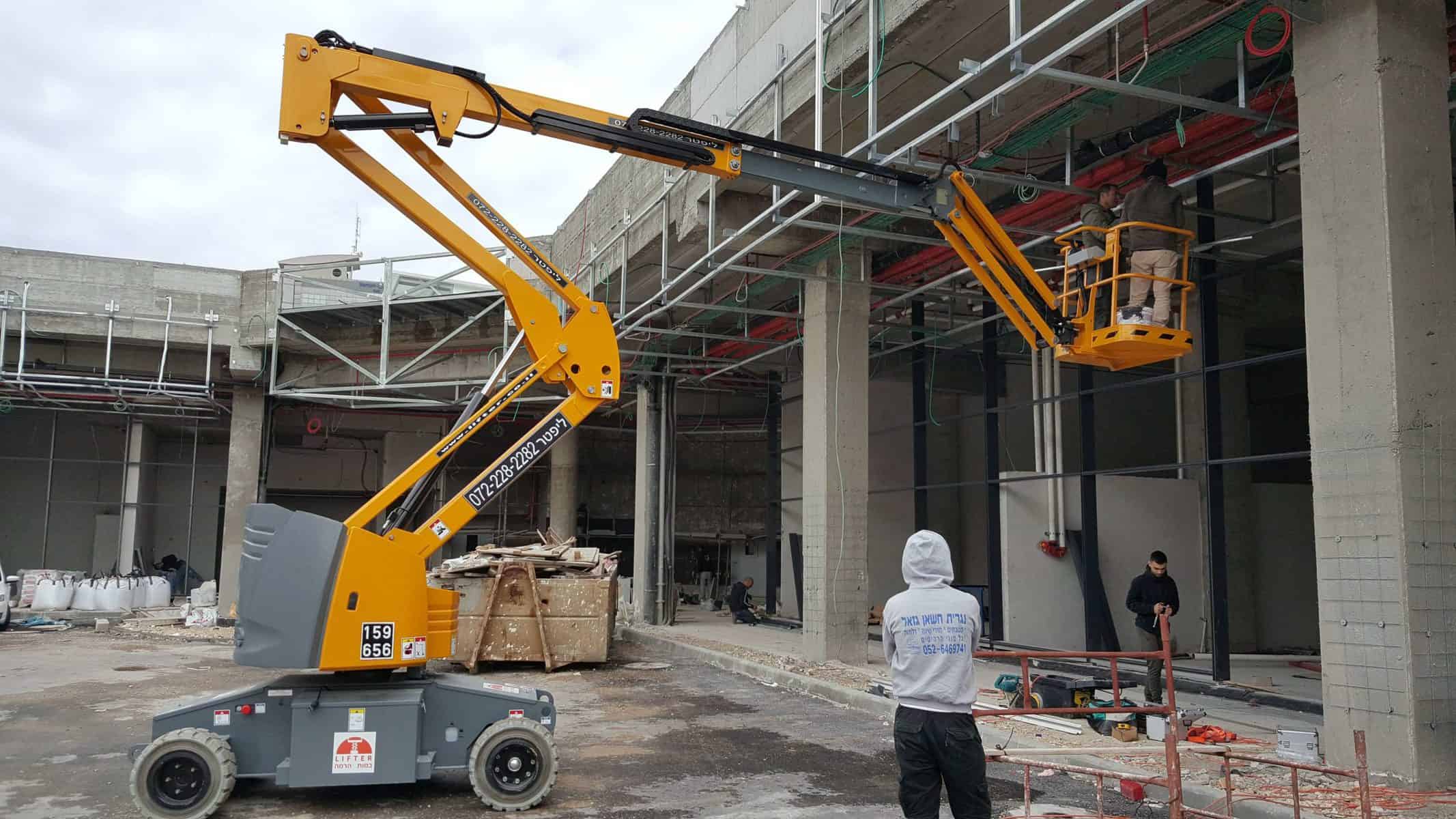 במת הרמה טלסקופית חשמלית צהובה בעבודת חוץ