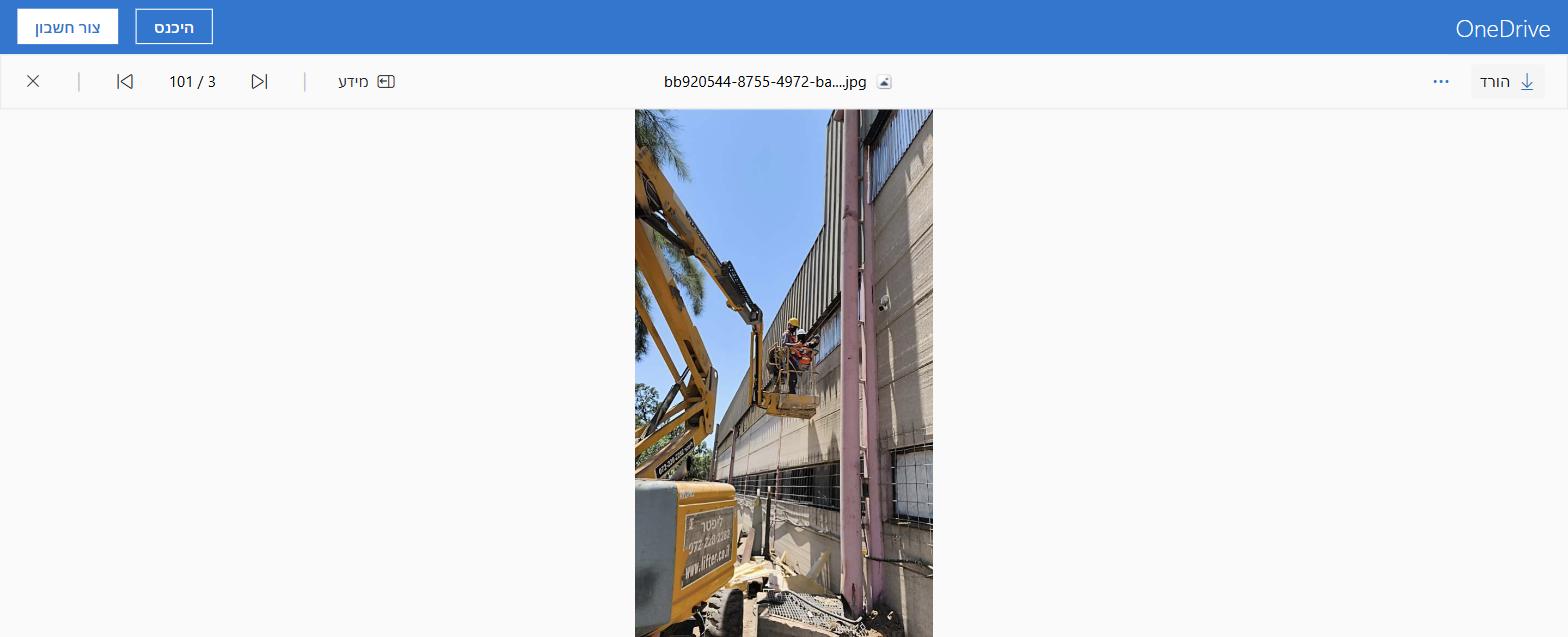 זרוע מפרקית של ליפטר בעבודה ליד חזית מבנה תעשייתי